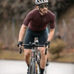 man in red long sleeve shirt riding on black bicycle